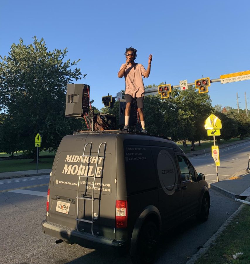 Ferrell Baker, known as ZZTaylor when performing, enthusiastically performs on top of his car in order to get his name out there in the music industry. 