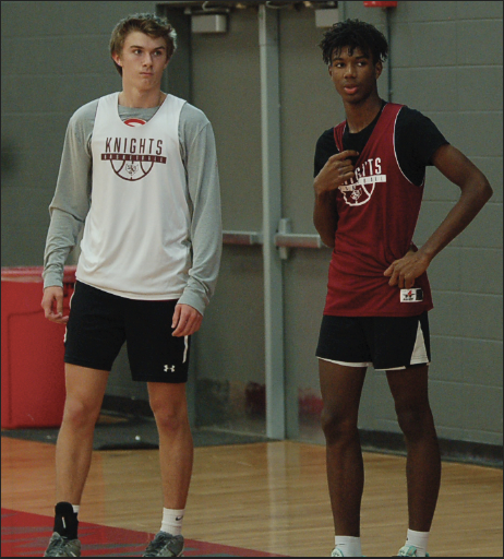 Senior captain Will Hunter, and sophomore Zuri Mesquitte stand in practice watching coach Taylor demonstrate a drill. 