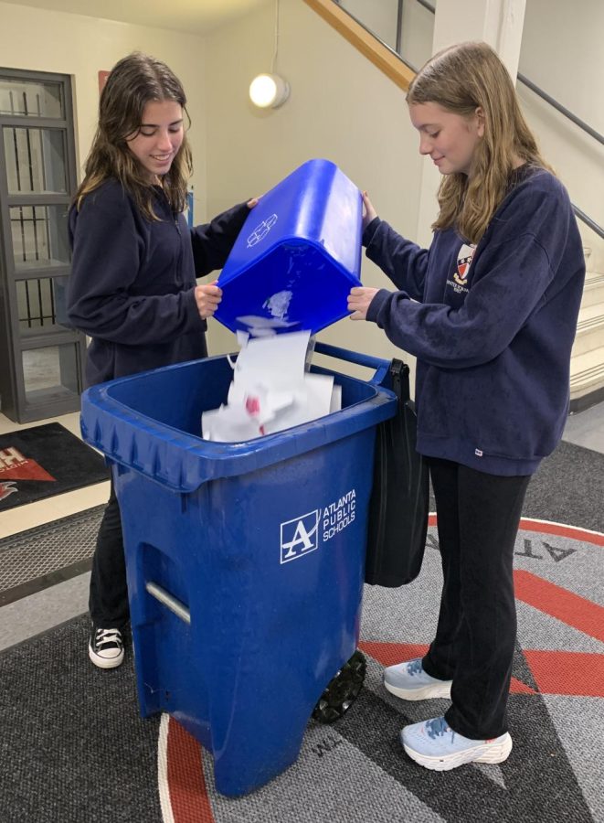 Sophomores Eden Sharp (left) and Eva Gustafson (right) empty classroom recycling bins at the end of the day.