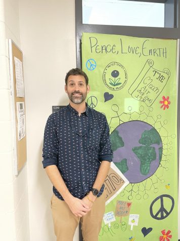 Michael Sanderson stands with his environmentally-decorated door that was completed during an Earth and Sustainability Club meeting. Sanderson is the teacher sponsor of the club.