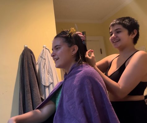 Senior Sara Sasser cuts Senior Piper Martinsens hair. Sara began cutting her own hair during COVID and has since expanded to styling her friends and familys hair too.