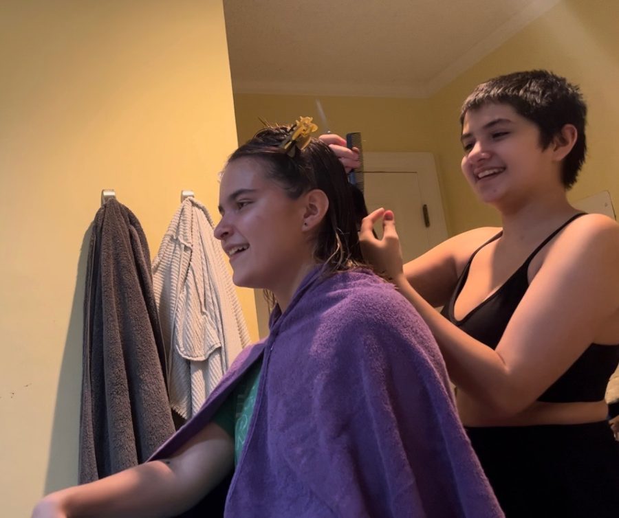 Senior Sara Sasser cuts Senior Piper Martinsens hair. Sara began cutting her own hair during COVID and has since expanded to styling her friends and familys hair too.