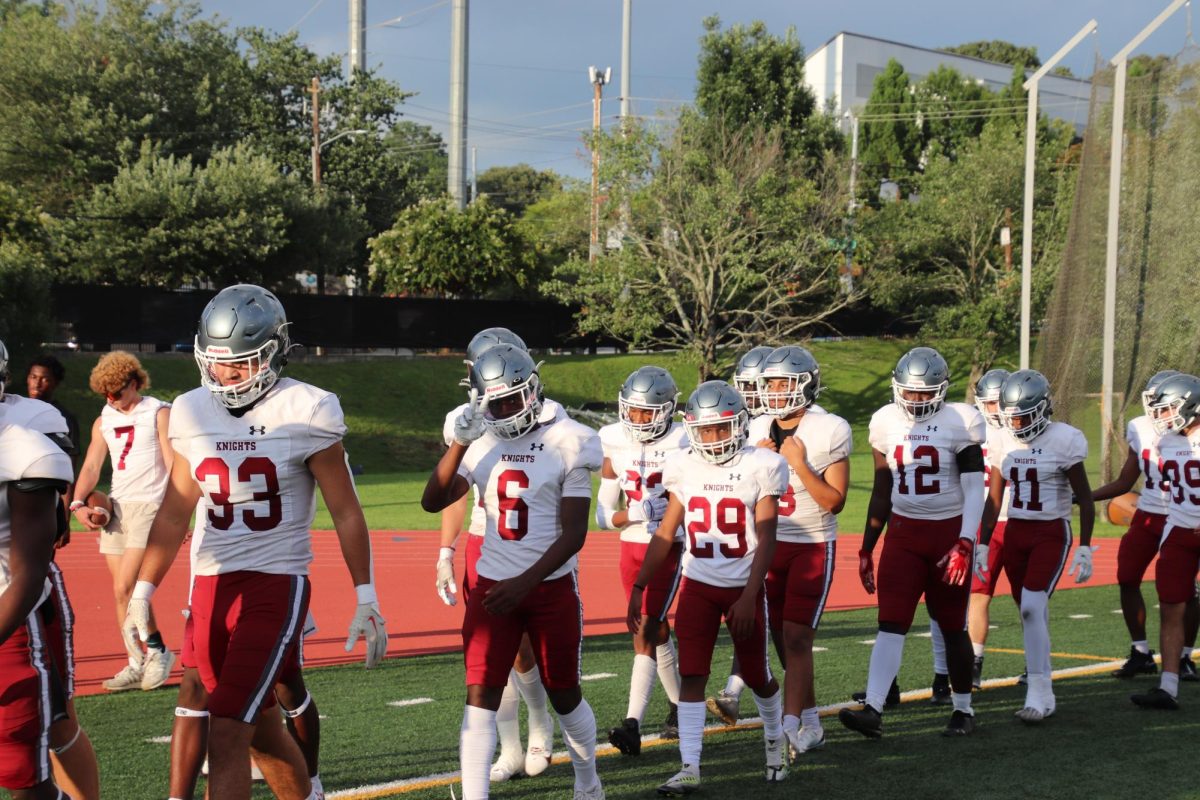 The football team walks onto the field in preparation for the first scrimmage of the season.