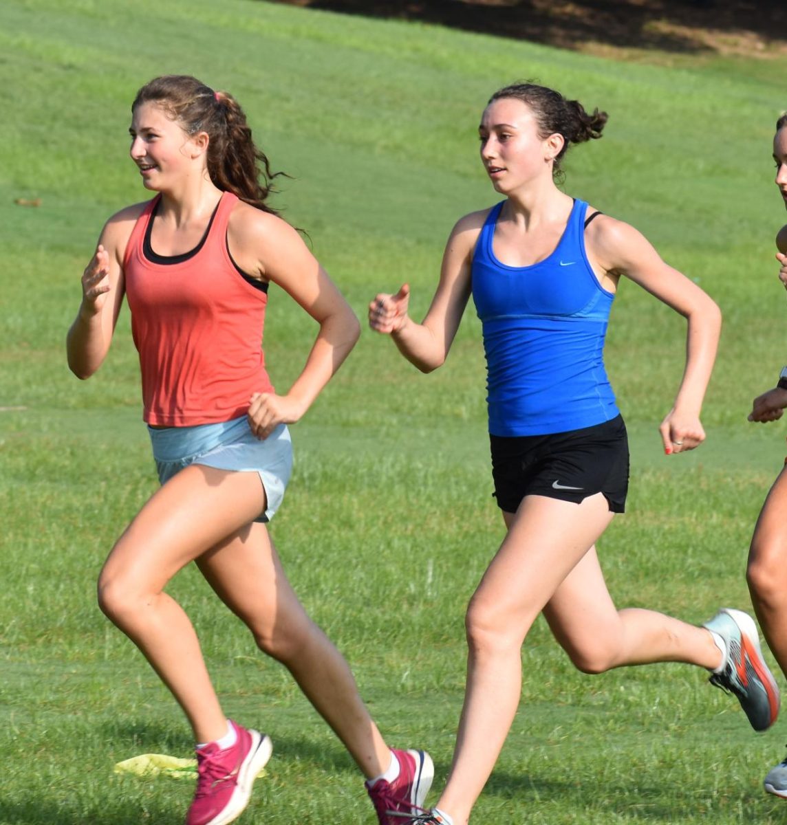 (Left to Right) Juniors Cate Barton and  Sierra Pape run strides at the end of practice on Aug. 12.