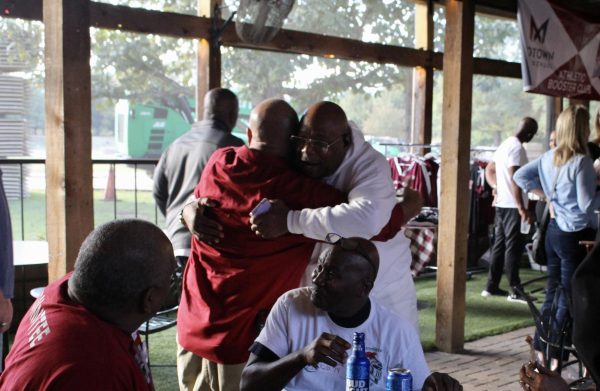Alumni greet each other with open arms when reuniting at the tailgate.