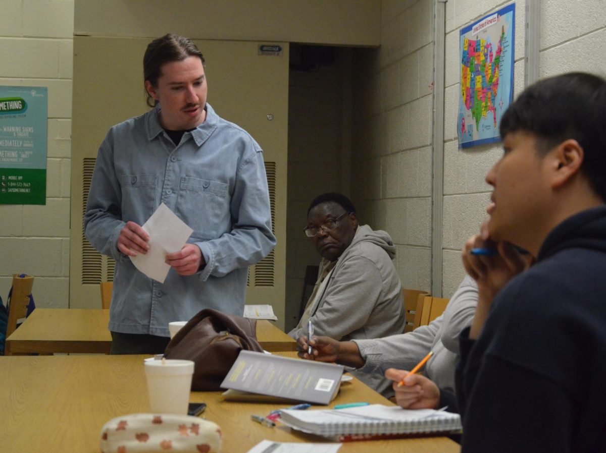 A HELPING HAND: ESOL teacher Joe Osborne helps students in the adult education center every day to learn necessary skills to obtain jobs and have better lives by improving their English fluency. Students learn necessary phrases homebuyers will encounter.
