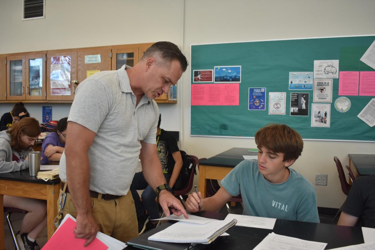 Curtis assists junior Alek Sibilsky in an AP Biology class. Curtis has been teaching sciences since he started working at Midtown.