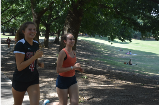 Seniors and captains Cate Barton (left) and Sierra Pape (right) finish a warm-up loop at practice in Piedmont Park. 