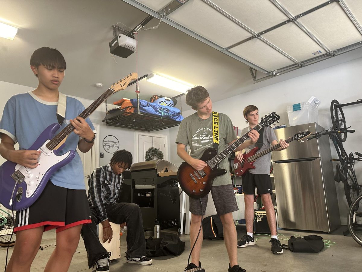 Nguyen, Blumm, Jackson, and English practice their first completed song 'The Police' in English’s garage.