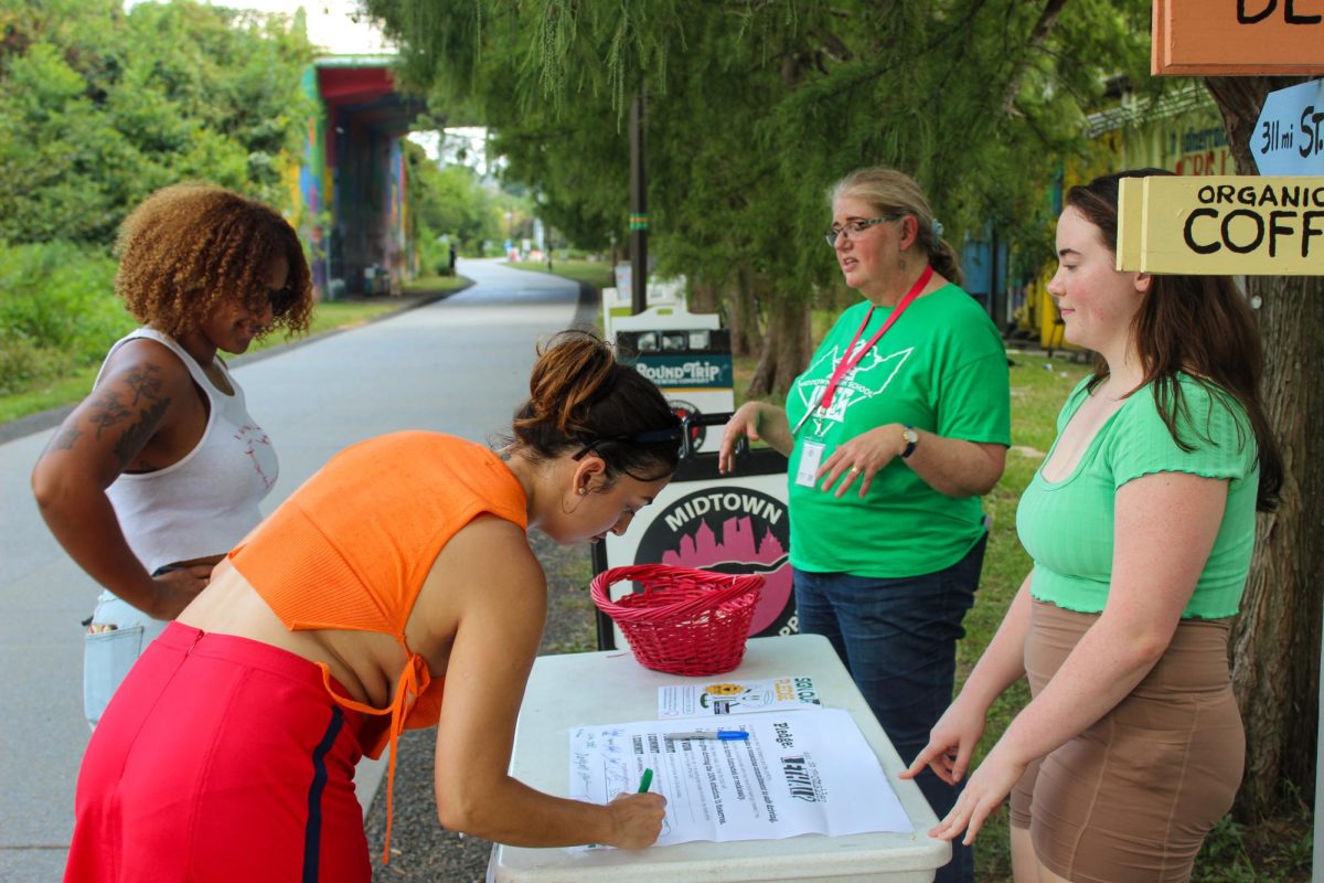 Impact Teen Drivers Club Adviser Mary Van Atta and Vice President Wavey Hodge advertise Impact Teen Drivers on the Beltline. They spread Impact Teen Driver's message through having people sign a safe driving pledge.