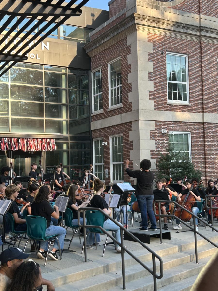 Orchestra director Krissi Davis, the 2019-2021 teacher of the year, leads the performance. 