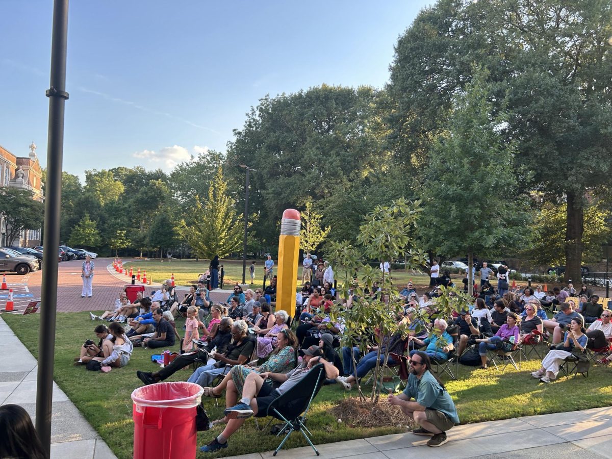 Parents gather on the lawn in front of the library to watch their children perform. 