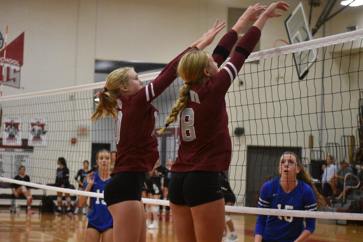 Sophomore Nora Goodman (left) and junior Siri Bluestone (right) block a hit against M.L. King on Sept. 4. The Knights won 2-0.