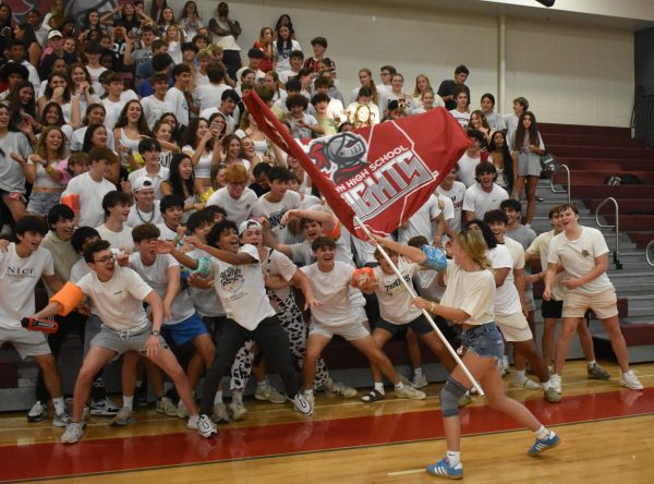 Senior Sammie Estep waves a Midtown Knights flag at the Aug. 27 varsity volleyball game against North Atlanta.