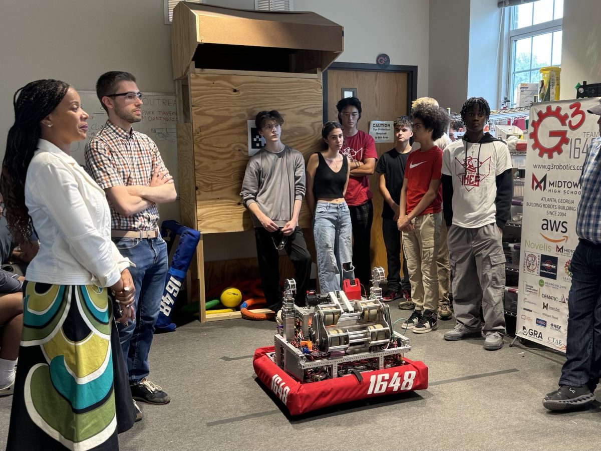 STUDENT COLLABORATION: G3 Robotics club mentors explain the robot students built in 2023 with State Senator Sonya Halpern. Halpern is taking advice from G3 students and mentors on a bill funding robotics teams in Georgia schools.