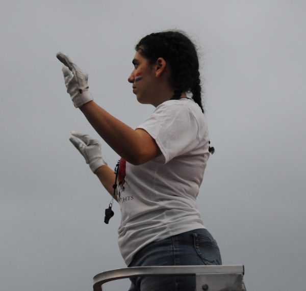 Senior Talia Pivoshenko leads the band during the Knights football game against Charles Drew. 