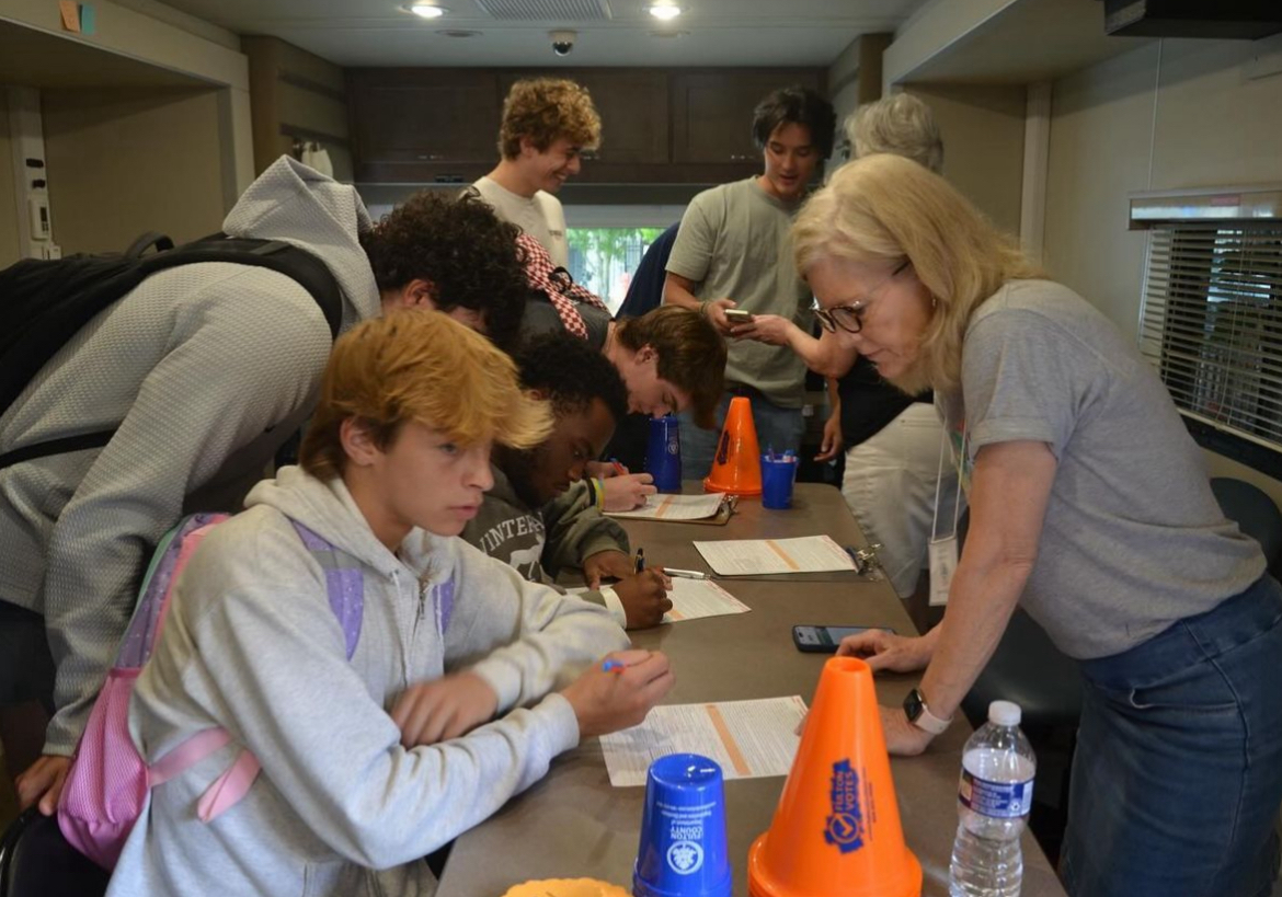 REGISTRATION STATION: Senior Camden Locke registers to vote with Fulton Voting Taskforce at its bus event. Midtown Votes  worked throughout the fall to educate and prepare students to vote in the November election.