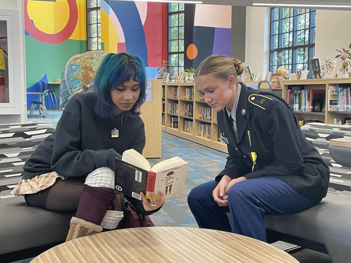 Sophomore Sikari Jones (left) and Blakey Roberts (right) read and discuss banned book "The Hate U Give" by Angie Thomas, a book listed in Project 2025 in the library after school.