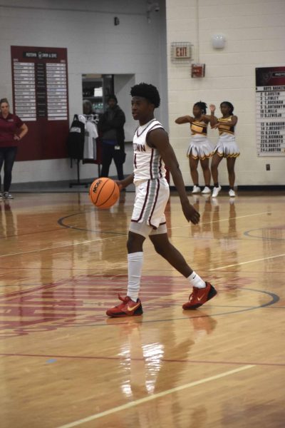 Junior Trent Bockman takes the ball up against Forest Park on Nov. 22. Both Trent and his sister Devin Bockman have played basketball since they were children, and he believes that their dynamic has pushed him to improve as a player.