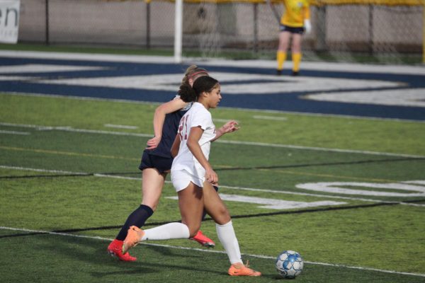 Junior McKenzie Godfrey (in white) dribbles forward against Decatur on Feb. 6, 2024. Godfrey scored three goals. (Courtesy of Ida Centner)