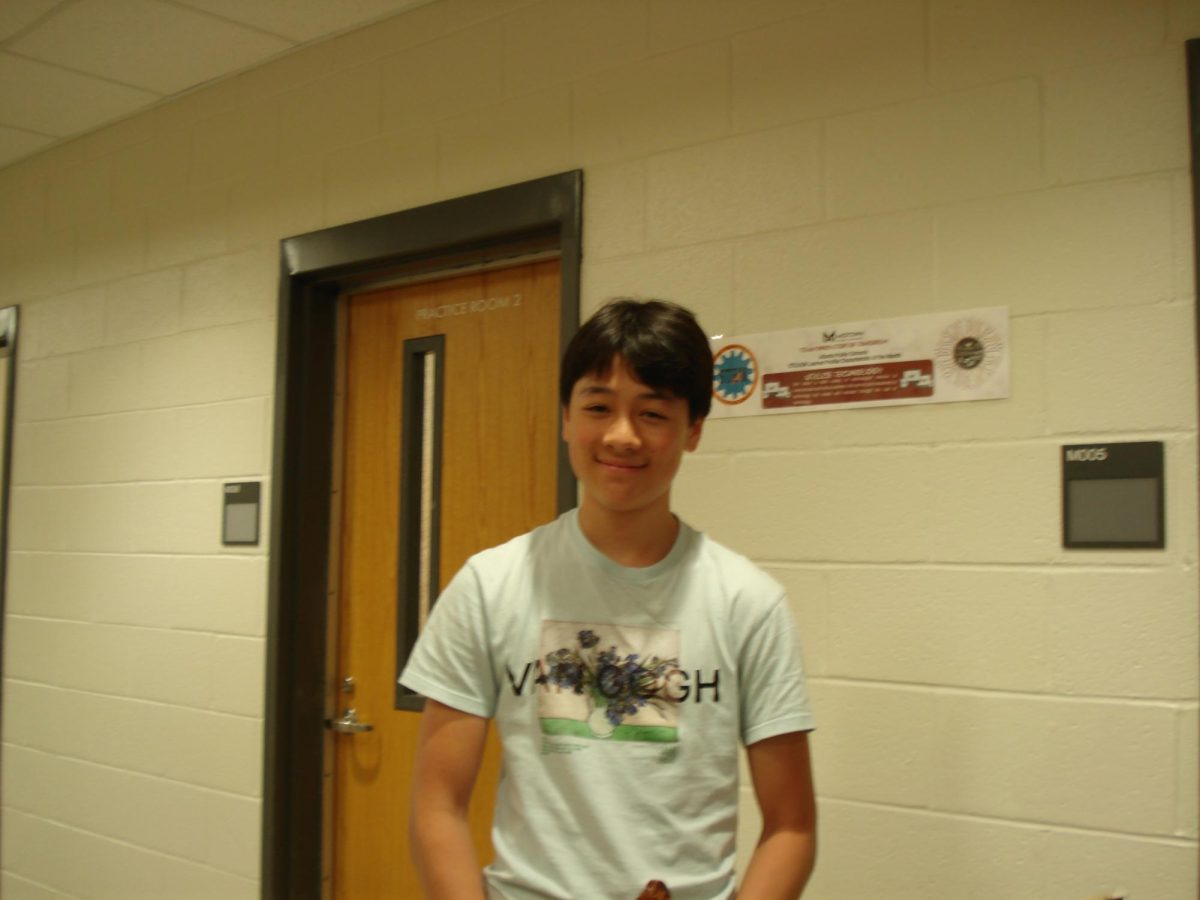 Sophomore Thomas Sehat pauses in the hallway in front of the orchestra room after practicing his violin.