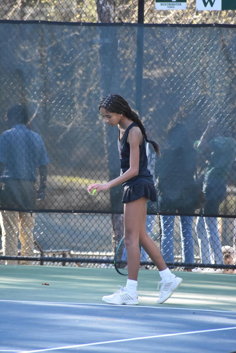 Freshman Mali Clark sets up to serve at a match against Westminster on March 25. The knights lost 5-0 and ended the season with an overall score of 4-5
