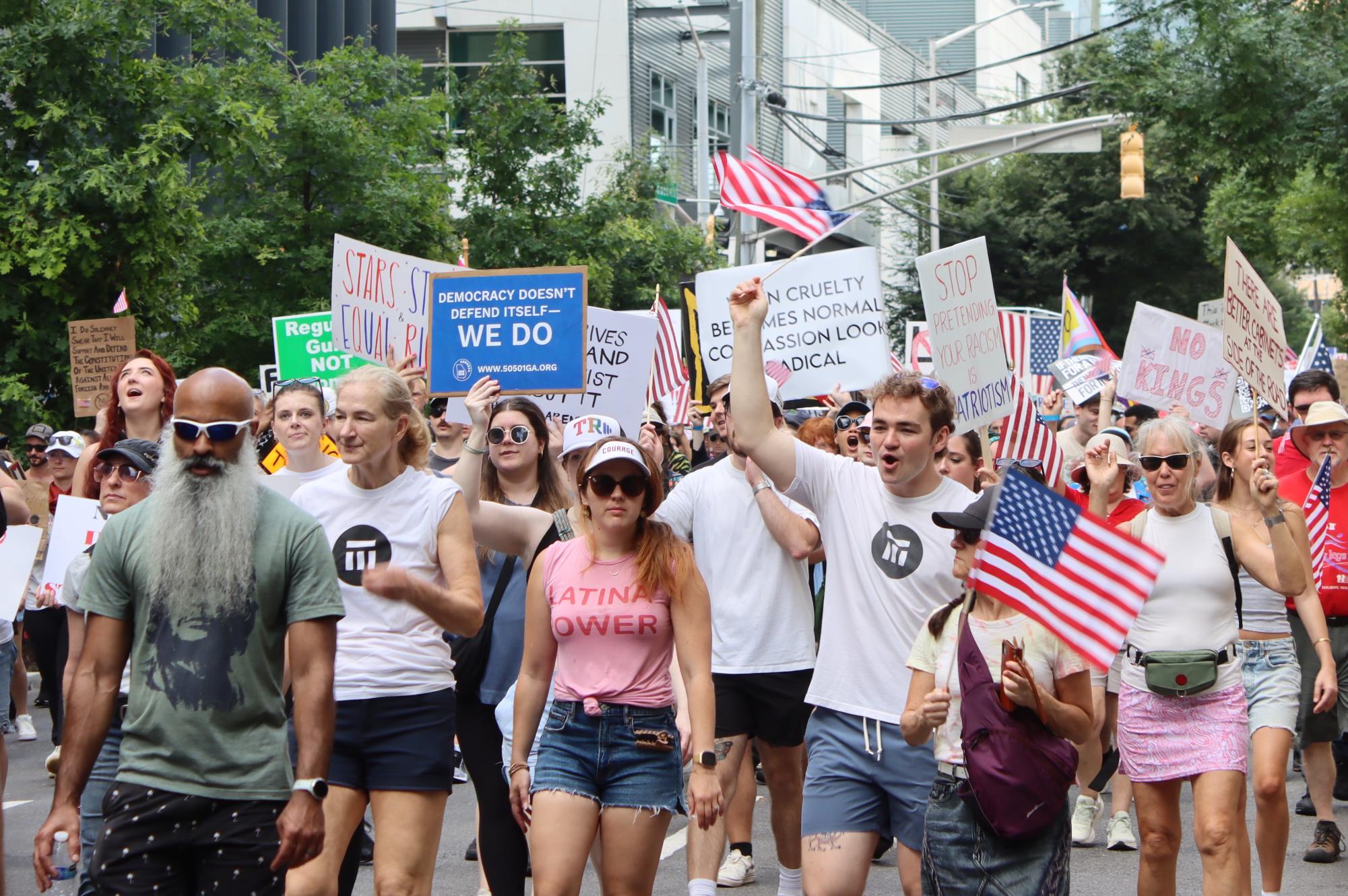 MARCHING FORWARD: After the protest at Liberty Plaza, protesters marched through the city streets with signs and American flags, and people came out on their balconies to watch.