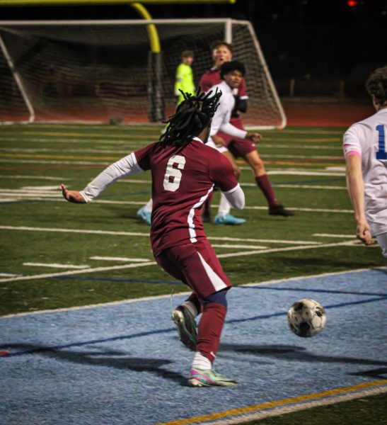 Senior Yoseph Samson dribbles upfield in the Knight's game against Paideia, where the boys won.