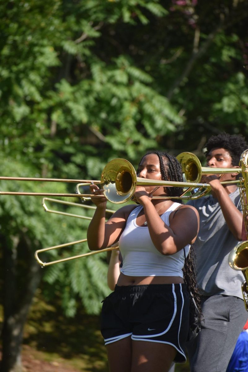Junior brass section leader Leila Yalew brings the spirit with an exciting trombone performance alongside the marching band.