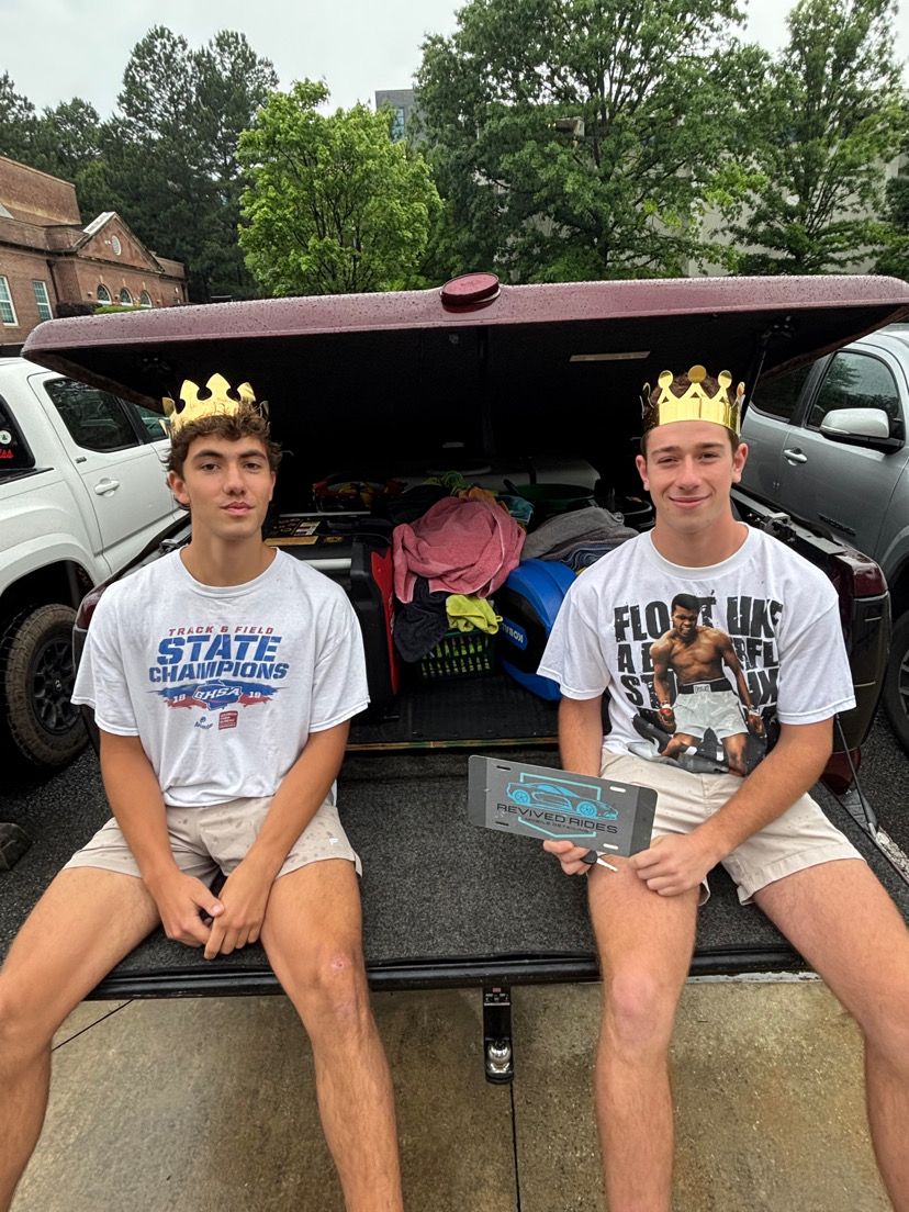 Seniors Ben Ille (left) and Ayden Conlon (right) sit on the trunk of their business's truck. The equipment in the truck has allowed for the students to greatly expand their business, ultimately detailing over 200 cars throughout their career.