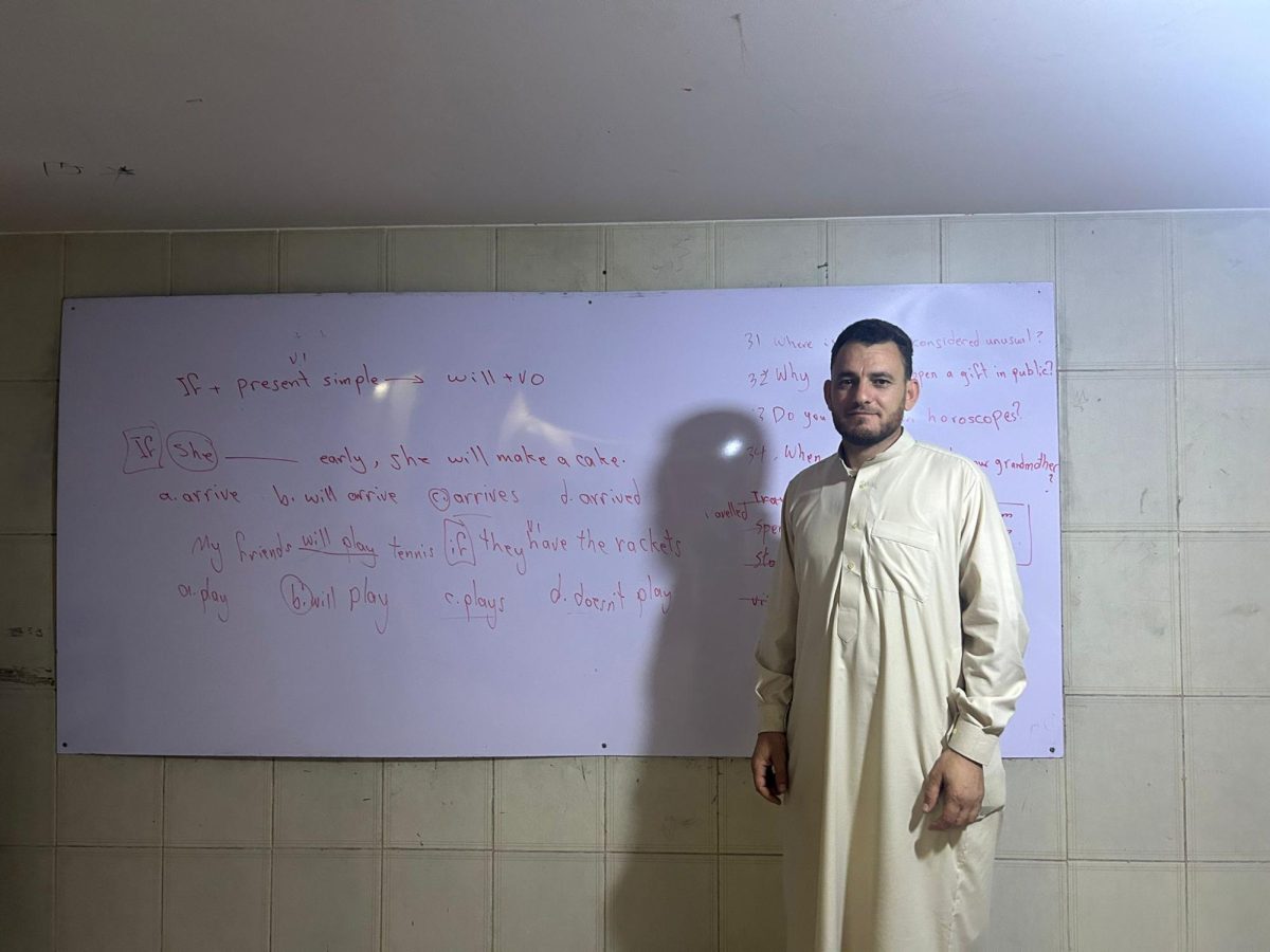 Syrian teacher Ahmed Zarzar stands in his classroom before a scheduled English class for his high school cohort.