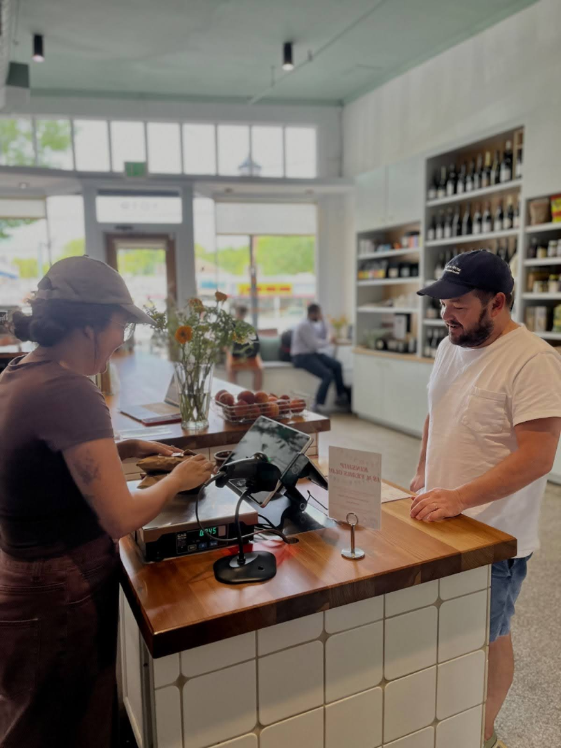 Employee, Jessica Garcia, checks out Kinship regular Jamie Butler. Butler comes almost every week to get premium steak that he can’t get anywhere else. “We definitely have the best regulars in Atlanta,” Garcia said.