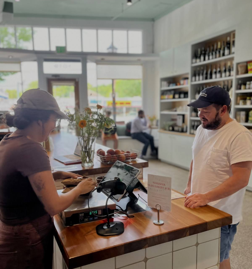 Employee, Jessica Garcia, checks out Kinship regular Jamie Butler. Butler comes almost every week to get premium steak that he can’t get anywhere else. “We definitely have the best regulars in Atlanta,” Garcia said.