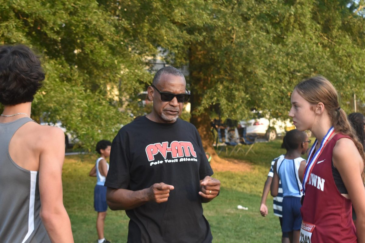 Head Coach Issac Seals converses with freshman Lia Sinitiere at APS series meet two on Sept. 3.