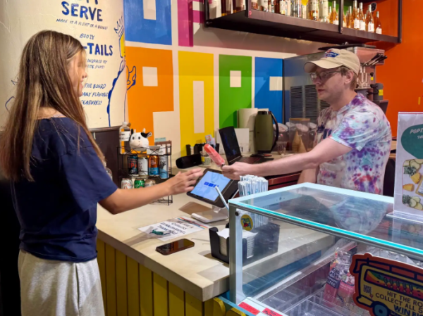 SERVICE WITH A SMILE: Junior Ramona Muse buys a King of Pops Popsicle from the Ponce City Market 'Beach Bar' location.