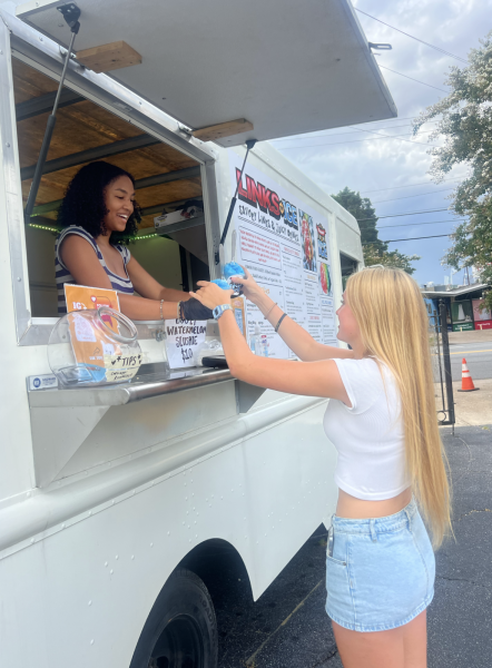 FUN FLAVORS: Nylah Isaac hands Blakely Roberts the best selling  Blue Raspberry Ice Cube Cone named after famous rapper Ice Cube.