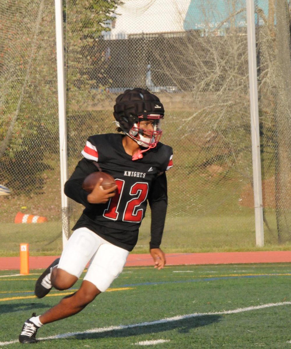 Junior Dorian Fox runs the ball down the field at the Knights game against Forest park. The Knights won 18-7. 