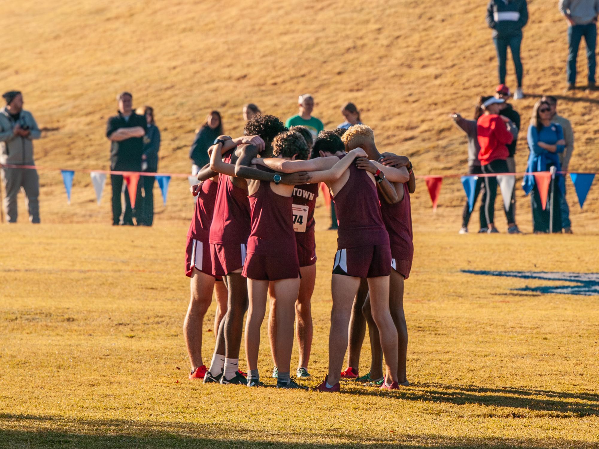 The boys cross country team huddles up before the 4A State Championship race. Senior Cameron Collier finished first overall individually, and the overall team placed 12th out of 24 teams. 