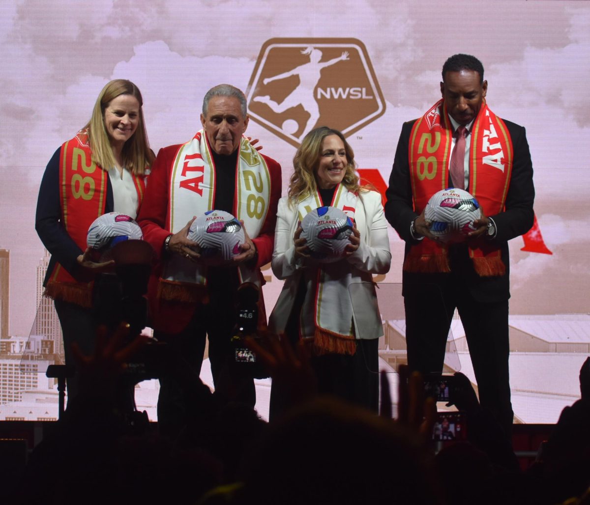 Cindy Parlow Cone, Arthur Blank, Jessica Berman and Andre Dickens smile before the cameras at the "Empower Her. Inspire All." event on Nov. 11, 2025, holding NWSL Atlanta 2028 branded balls. The team is set to play in Mercedes-Benz Stadium beginning in 2028.