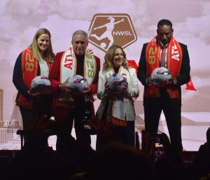 Cindy Parlow Cone, Arthur Blank, Jessica Berman and Andre Dickens smile before the cameras at the "Empower Her. Inspire All." event on Nov. 11, 2025, holding NWSL Atlanta 2028 branded balls. The team is set to play in Mercedes-Benz Stadium beginning in 2028.