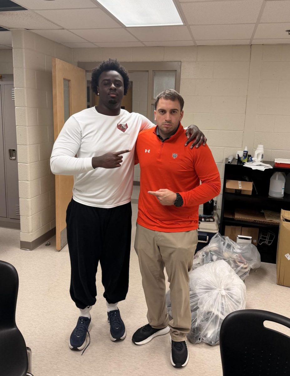 Mensah poses with Mercer special teams  and outside linebacker coordinator Brandon Taylor on his official visit to Mercer.