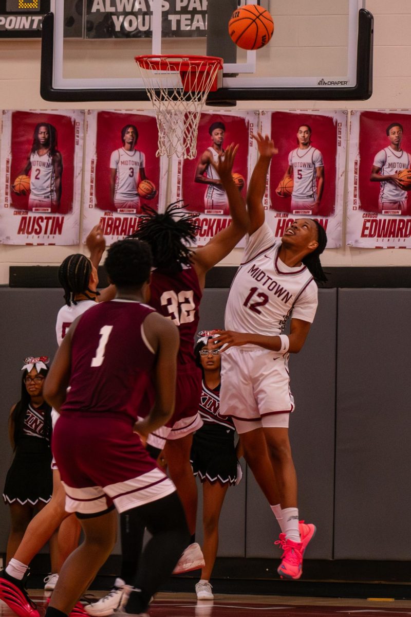 Senior Lawrence Barreau jumps up to tip the ball into the basket. The Knights won 76-57 against Maynard Jackson on Feb. 20.