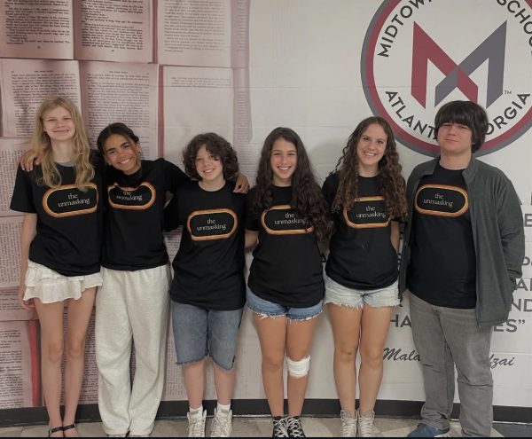 STAFF SWAG: The Unmasking staff shows off their staff shirts, advertising the release of the annual addition of the magazine. (CREDIT: Unmasking)