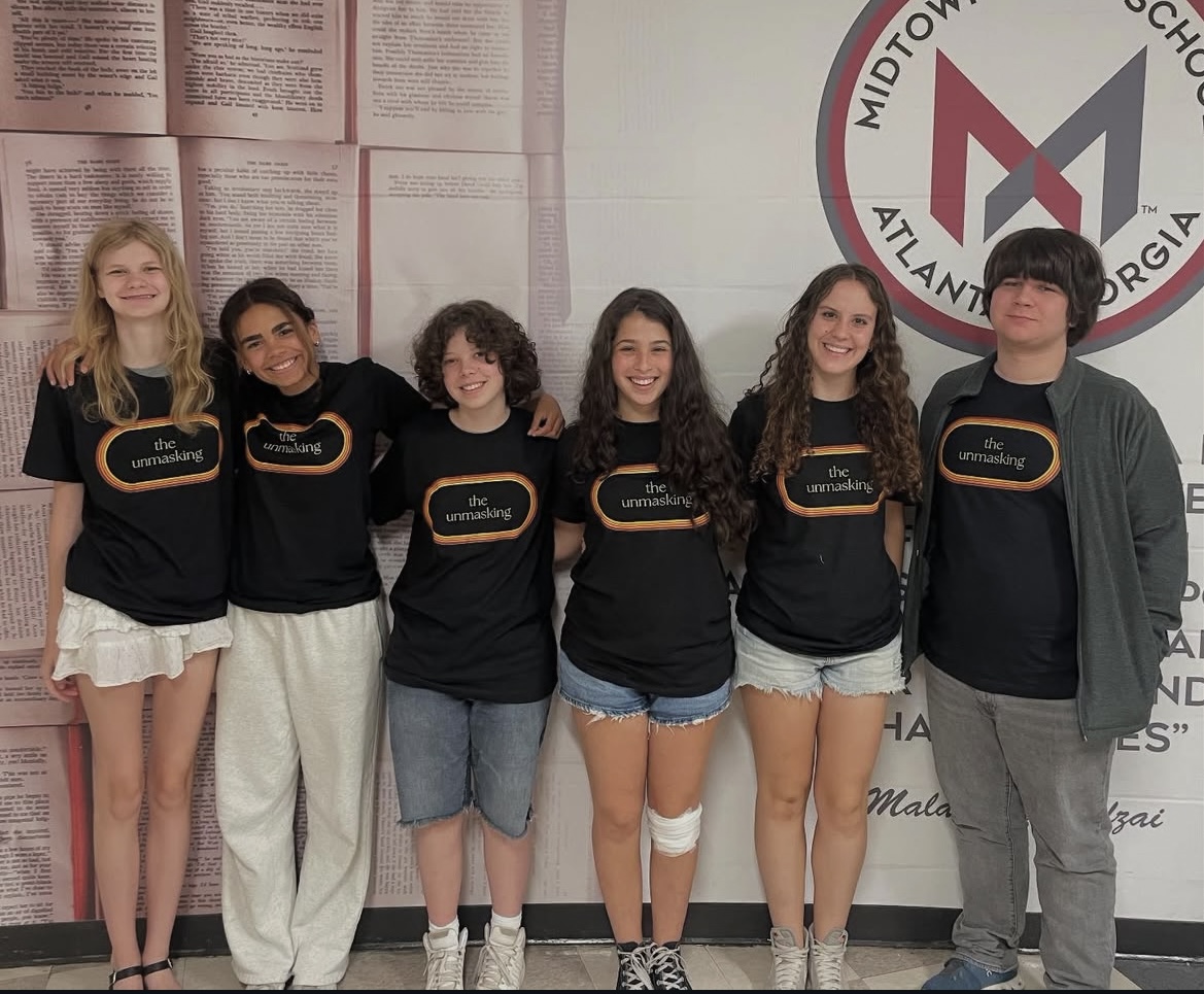 STAFF SWAG: The Unmasking staff shows off their staff shirts, advertising the release of the annual addition of the magazine. (CREDIT: Unmasking)