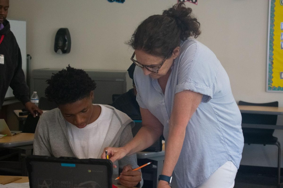 ONE-ON-ONE LEARNING: Retiring algebra I teacher Carrie Rowe helps students at the Math Center, where she is able to provide specialized learning assistance.