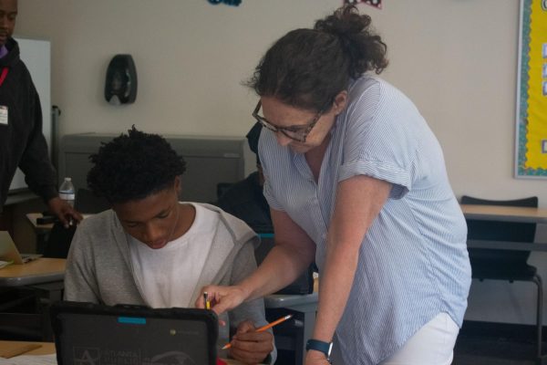 ONE-ON-ONE LEARNING: Retiring algebra I teacher Carrie Rowe helps students at the Math Center, where she is able to provide specialized learning assistance.