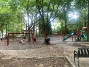 Families with young children gather in Sidney Marcus Park on a weekday evening.