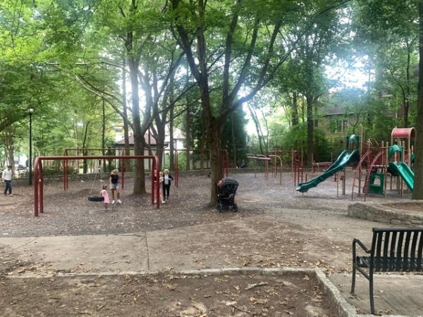 Families with young children gather in Sidney Marcus Park on a weekday evening.