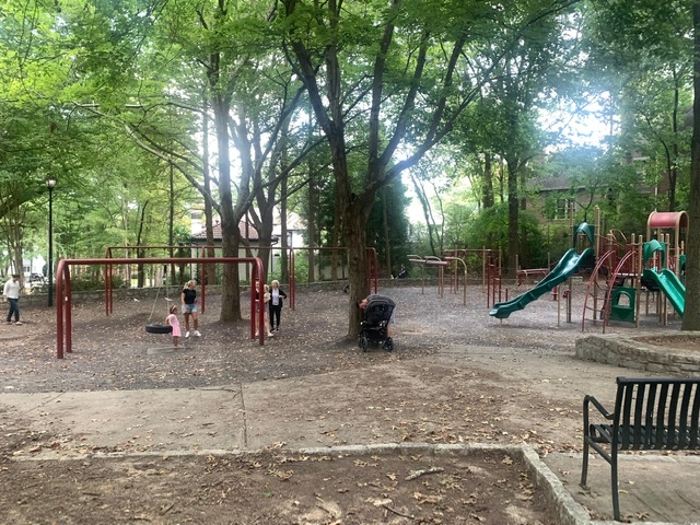Families with young children gather in Sidney Marcus Park on a weekday evening.