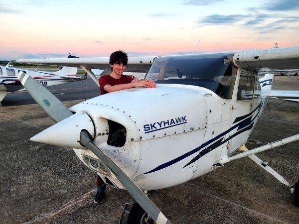 Sophomore Ronan Weyandt poses next to a similar model of airplane as the one he flew in during his first solo flight on April 10.